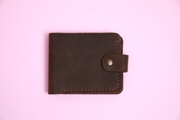 Stylish brown leather wallet on pink background, top view