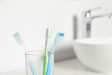 Plastic toothbrushes on blurred background,, closeup. Space for text