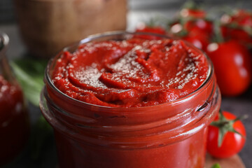 Jar of tasty tomato paste on table, closeup
