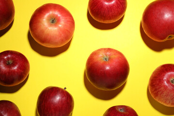 Ripe red apples on yellow background, flat lay