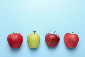 Ripe red and green apples on light blue background, flat lay. Space for text