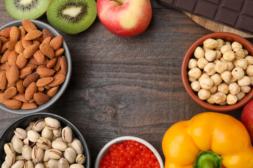 Frame made of many different products on wooden table, flat lay and space for text. Natural sources of serotonin