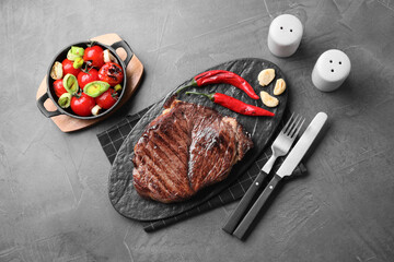Delicious fried beef meat served on grey table, flat lay