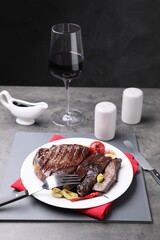 Delicious grilled beef meat served on grey table