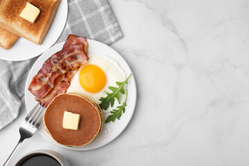 Tasty pancakes served with fried egg and bacon on white table, flat lay. Space for text