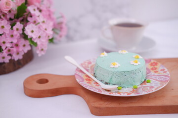 Green tea mousse cake with cup of coffee on the table.