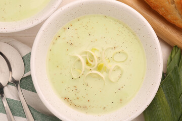 Bowl of tasty leek soup on table, top view