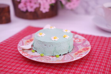 Green tea mousse cake with cup of coffee on the table.