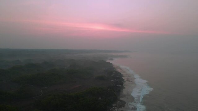 Red sunrise over foggy sea coastline, aerial view