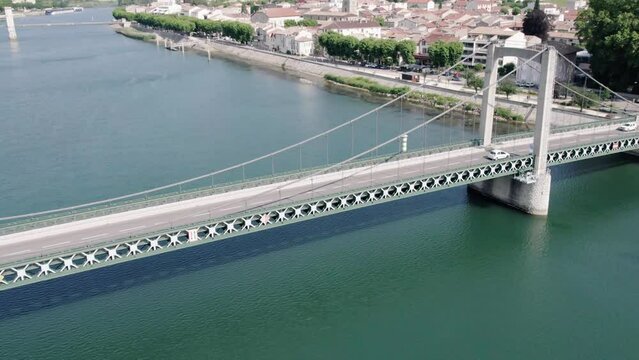 Aerial Tracking Shot of a White Car On Bridge Over the Rhone River Facing the Vineyard At Tain l'Hermitage