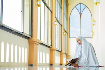 The image of an Asian Muslim woman is praying with tranquility and faith, The peace in the mosque makes it an energetic atmosphere of faith.