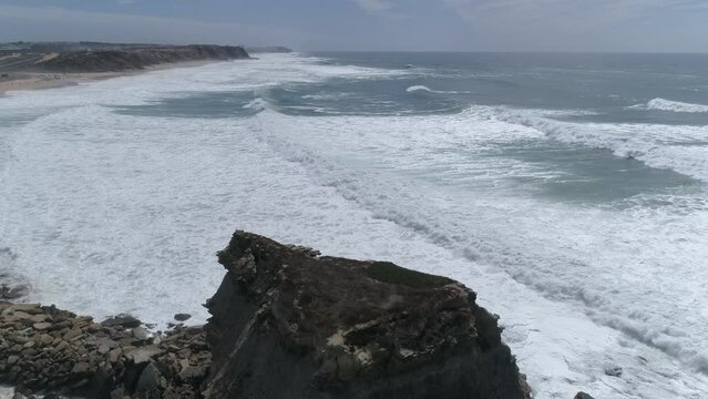 Large rock in the blue sea on a sunny day. Aerial view Rocky cliff in the ocean in  Portugal