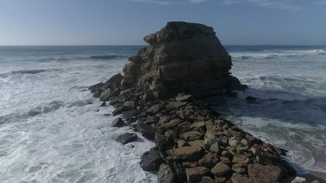 Large rock in the blue sea on a sunny day. Aerial view Rocky cliff in the ocean in  Portugal