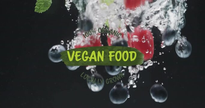 Animation of vegan food text over fruit falling in water background