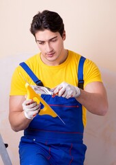 Young contractor employee applying plaster on wall