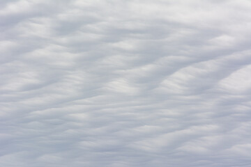 Fototapeta premium Abstract cloud texture with a wavy, sand dune pattern.