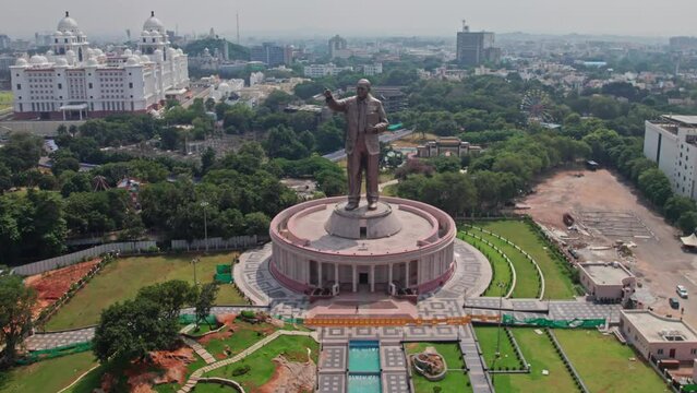 Big bronze statue of Dr Babasaheb Ambedkar  near NTR Marg at hyderabad, telangana with telangana secretariate at background aerial drone push in shot 4k