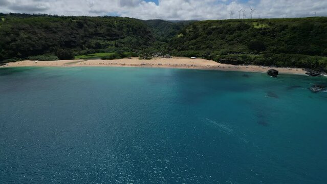 Waimea Bay Beach, O'ahu, Hawaii during the day cliff jumping, churches, wind turbines