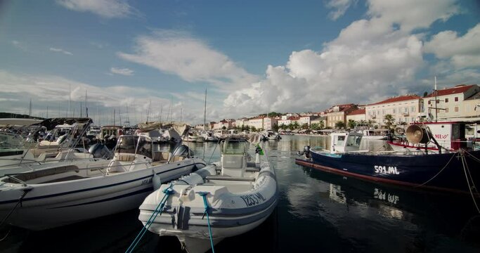 Boats docked at pier in Mali Losinj Croatia bob in clear water at midday