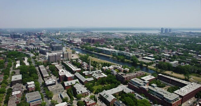 Aerial tracking shot of the Lachine Canal and Pointe-Saint-Charles, in sunny Montreal