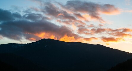 Obraz premium a silhouette of a mountain against the sky with clouds at sunset