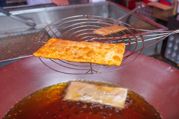Typical Brazilian pastry being fried at the fair (Pastel de feira frito)