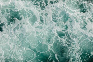 Serene body of blue water featuring white foam crests on the top of the waves.