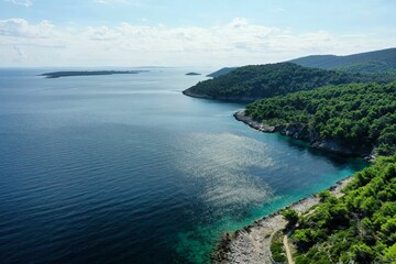 Fototapeta premium Aerial view of a scenic landscape of island in Croatia with lush greeen trees on the shore
