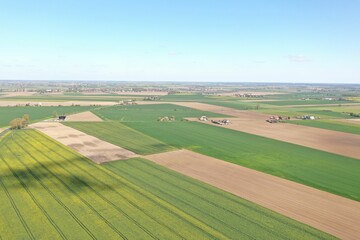 Aerial view of a rural landscape with cultivated fields, crop lines, and other farmland