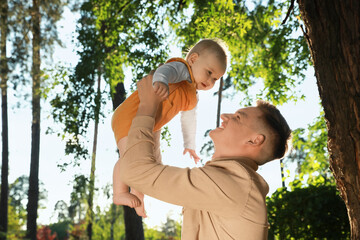 Father with his cute daughter spending time together in park on summer day