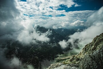 Stunning aerial view of a mountainous landscape with fluffy white clouds dotting the sky