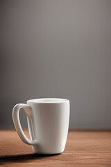 AI generated illustration of a ceramic white cup on wooden table, vertical shot