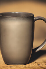 Obraz premium AI generated illustration of a ceramic brown coffee mug on wooden table, vertical shot