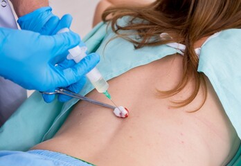 Young back injured woman visiting male doctor chiropractor