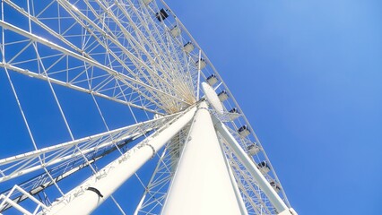 White Ferris wheel against a picturesque sky