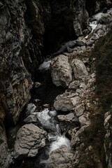 Fototapeta na wymiar Small waterfall cascading down a rocky ravine in a narrow valley