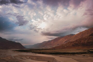 Scenic view of barren mountains under a cloudy sky