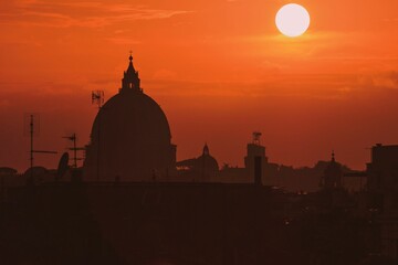 Obraz premium St Peter's Basilica silhouette with an orange sunset sky in the background
