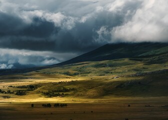 Obraz premium Scenic shot of a landscape with a dense clouds covering the mountains in the background