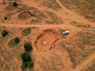 Aerial view of bomb craters on a dry field in Laos