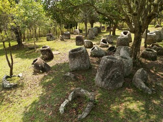 Historic Plain of Jars on a grassy green field in Laos