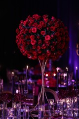 Beautiful bouquet of red roses arranged in a centerpiece at a wedding ceremony.