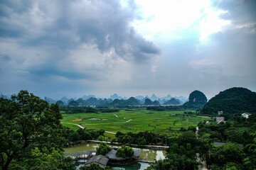 Aerial view of greenery field surrounded by dense trees in Guilin
