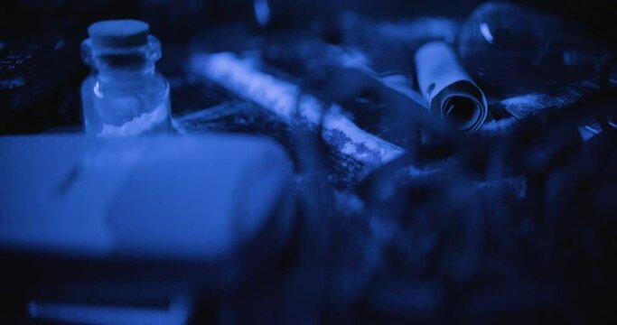 Closeup of a burning powder surrounded by wires and flasks in cold blue tones