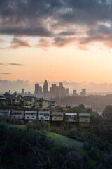 some houses sitting on a hill with the city in the background: Los Angeles, California
