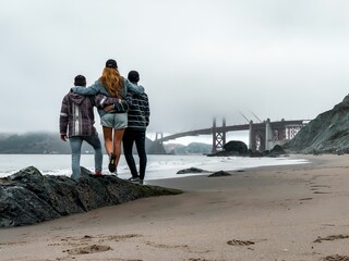 Group of friends overlooking the Golden Gate bridge in San Francisco, California on a foggy day