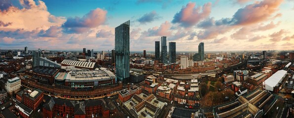 Aerial view of a bustling cityscape of Manchester at sunset.