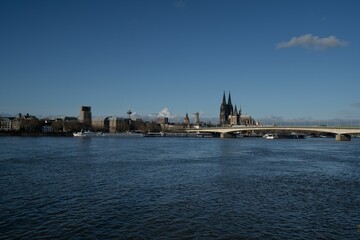 a large bridge over a river near a city skyline with a church in the distance