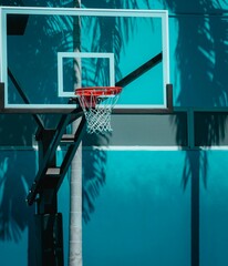 Outdoor basketball hoop situated in front of a bright blue wall