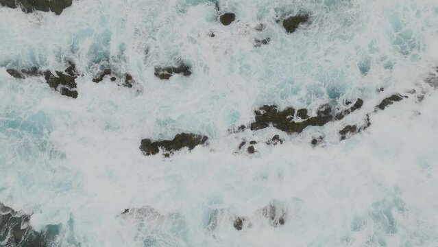Dangerous Ocean waves - topshot aerial drone shot. Static picture of sea waves hitting the rocks. Dynamic white water.